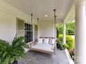 Inviting front porch featuring a porch swing with plush cushions and beautiful plantings at 2636 Chilton Pl, Charlotte, NC 28207