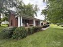 Traditional brick home with large front porch, rocking chairs, and manicured landscaping on a green lawn at 360 S Brady Ave, Newton, NC 28658
