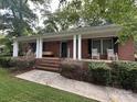 Inviting brick home featuring a covered front porch with columns and a well-maintained front lawn at 360 S Brady Ave, Newton, NC 28658