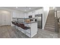 Modern white kitchen featuring an island with bar seating and stainless steel appliances at 4060 Beacon Ave # 148, Monroe, NC 28110
