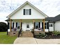 Inviting front porch with black railings, brick stairs, wood pillars, and planters at 4282 Brandy Creek Ct, Clover, SC 29710