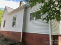 View of the side exterior showing brick foundation and white siding at 517 Western Ave, Statesville, NC 28677