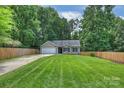Beautiful one-story home featuring a spacious front yard, manicured lawn, and a charming exterior at 5179 Poplar Glen Dr, Matthews, NC 28104