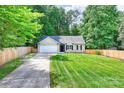 Lovely single-Gathering home showcasing a lush green lawn, mature trees, and a private driveway at 5179 Poplar Glen Dr, Matthews, NC 28104