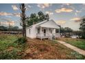 Quaint home with a covered front porch and freshly painted white exterior, nestled in a quiet setting at 601 N Johnson St, Monroe, NC 28112