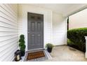 Inviting front porch with a gray front door, decorative plants, and a 'Welcome Home' doormat at 6340 Green Vista Ct, Charlotte, NC 28212