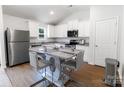 Modern kitchen featuring white cabinets, stainless steel appliances, and a central island with seating at 672 Lamorak Pl, Richburg, SC 29729