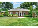 Classic brick ranch with mature landscaping, a well-manicured lawn, and inviting curb appeal at 935 Trentle Ct, Charlotte, NC 28211