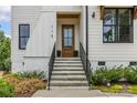 Inviting front entrance with stone steps, black iron railing, and a natural wood front door at 113 Prince St, Belmont, NC 28012