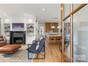 Open-concept living room featuring a fireplace, hardwood floors, and views of the modern kitchen at 113 Prince St, Belmont, NC 28012