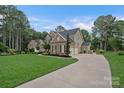 View of home highlighting the extended driveway, garage, and surrounding greenery at 116 Ivy Hollow Ln, Mooresville, NC 28117