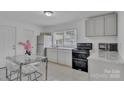 Inviting eat-in kitchen with sleek appliances, white cabinetry, granite countertops, and tile flooring at 123 E Farmview St, Gastonia, NC 28054