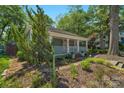 Cozy single-story home featuring a welcoming front porch and lush, landscaped surroundings at 1500 Pecan Ave, Charlotte, NC 28205