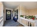 Cozy front porch with a decorative wreath, a blue bench, and vibrant potted plants at 17931 Kings Point Dr # E, Cornelius, NC 28031