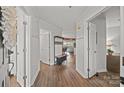 Bright hallway with wooden floors, white wainscoting, and views into other living spaces at 17931 Kings Point Dr # E, Cornelius, NC 28031