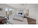 Sunlit main bedroom featuring a cozy bed with blue accents, a ceiling fan, and ample closet space at 17931 Kings Point Dr # E, Cornelius, NC 28031