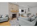 Cozy living room featuring a stone fireplace, hardwood floors, and comfortable seating at 2117 Middlebridge Ct, Fort Mill, SC 29715