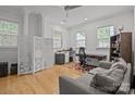 Bright office features hardwood floors, neutral walls, and a comfortable gray sofa at 2117 Middlebridge Ct, Fort Mill, SC 29715