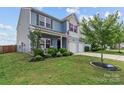 Charming two-story home with a well-manicured lawn and a two-car garage at 214 Hidden Lakes Rd, Statesville, NC 28677