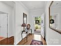 Bright entryway features hardwood floors, a stylish console table, and a decorative mirror enhancing the home's charm at 2473 Riparian Way, Denver, NC 28037