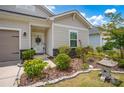 View of a nicely landscaped home with a decorative front door, adorned with vibrant plants and a stone lantern at 2473 Riparian Way, Denver, NC 28037