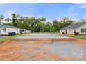 This construction site showcases a brick foundation, gravel infill, and plumbing stubs amidst a residential landscape at 263 Robinson St, Rock Hill, SC 29730