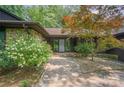 Inviting front entrance with stone walkway and decorative shrubs leading to a modern glass-paneled door at 3041 Shallowood Ln, Charlotte, NC 28277