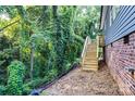 Backyard view of the wooden stairs from the side of the house, surrounded by greenery at 354 Moore Ave, Mooresville, NC 28115