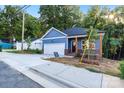 Blue house with a garage and a 'For Sale' sign on a sunny day in a residential area at 354 Moore Ave, Mooresville, NC 28115
