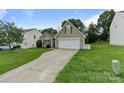 Inviting one-story home with a two-car garage, complemented by a well-maintained lawn and landscaped features at 406 Courtland Ct, Kannapolis, NC 28081