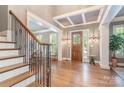 Elegant home foyer featuring hardwood floors, decorative lighting, and a staircase with ornate iron railing at 5537 Challis View Ln, Charlotte, NC 28226