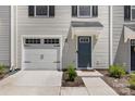 Close up of a townhome featuring a garage door, front door, and small shrubbery in front at 5690 Granbury Dr, Kannapolis, NC 28081