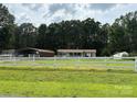 View of home with a white fence in the front of the large yard and canopy in the back at 7010 Executive Cir, Denver, NC 28037