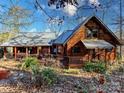 Inviting log cabin with a metal roof, showcasing covered porches and natural wood accents at 720 Potneck Rd, Salisbury, NC 28147