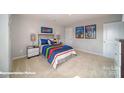 Comfortable bedroom featuring a colorful bed, carpeted floors, and stylish lamps at 7878 Old Brook Rd, Sherrills Ford, NC 28673