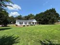 Single-story home on a large lot featuring mature trees and a well-manicured lawn at 8122 Hutchison Ln, Vale, NC 28168