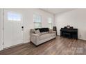 Cozy living room with hardwood floors, a comfortable sofa, and plenty of natural light from two windows at 9529 Cotswood Pl, Gastonia, NC 28056