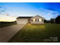 Charming single-story home at dusk with attached two car garage at 103 Chambwood Ln, Shelby, NC 28152