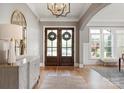Elegant foyer featuring hardwood floors, a decorative mirror, and double doors with wreath accents at 11008 Strike The Gold Ln, Waxhaw, NC 28173