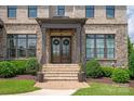 Close-up of the stately front entrance with beautiful double doors and manicured landscaping at 11008 Strike The Gold Ln, Waxhaw, NC 28173