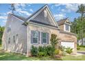 Inviting two-story brick home featuring manicured landscaping, gray shutters and complementary gray siding at 11226 Dappled Light Trl, Charlotte, NC 28227