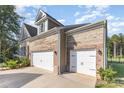 Spacious two-car garage with white doors complementing the brick exterior and well-maintained surroundings at 11226 Dappled Light Trl, Charlotte, NC 28227