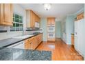 Bright kitchen features wooden cabinets, granite countertops and hardwood floors at 114 Larkfield Dr, Waxhaw, NC 28173