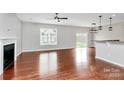 Bright living room with hardwood floors, a modern ceiling fan, a fireplace, and a view of the outdoor patio at 1314 San Gabriel Ave, Charlotte, NC 28214