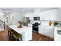 Modern white kitchen with stainless steel appliances, center island, and hardwood floors at 149 Parker Claire Ln, Kings Mountain, NC 28086