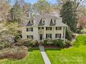 Beautiful two-story home featuring a manicured lawn, dormer windows and lush landscaping creating an inviting curb appeal at 1579 Queens W Rd, Charlotte, NC 28207