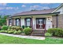 Inviting front entrance with brick steps, decorative railing, and manicured landscaping at 1658 Buckingham Ave, Gastonia, NC 28054