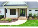 Charming front porch featuring brick steps, rustic columns, and landscaped garden at 176 Windwood Ln, Troutman, NC 28166