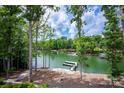 Scenic lake view featuring docks, blue skies, lush trees, and peaceful waters at 176 Windwood Ln, Troutman, NC 28166