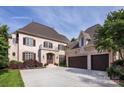 Elegant two-story home with a three car garage, balcony, manicured lawn, and front yard landscaping at 20635 Queensdale Dr, Cornelius, NC 28031